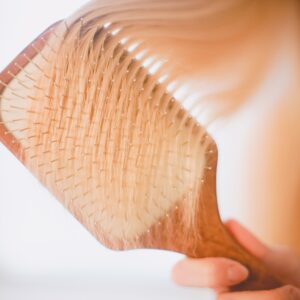 Paddle Brush durchkämmt blondes Haar.