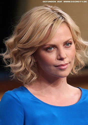 Charlize Theron mit femininen, blonden Wellen