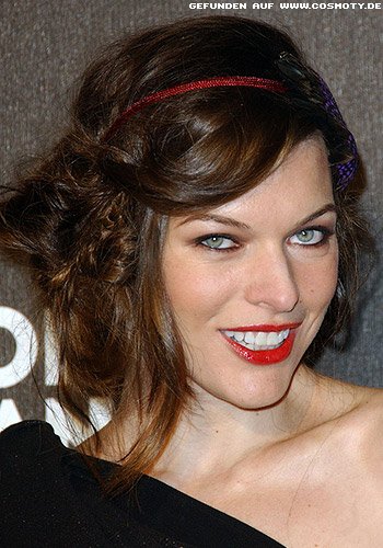 Milla Jovovich schückt hochgesteckte Locken mit Haarband