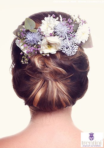 Üppig geschlungener Chignon mit extravaganten Blüten