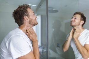 Mann beim Auftragen eines Eau de Toilettes