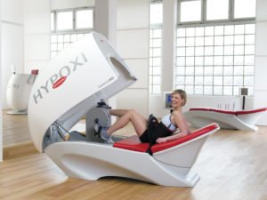 Eine Frau sitzt in einem geöffneten Hypoxi Gerät 