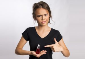junge Frau ist unzufrieden mit einem gefälschten Parfum