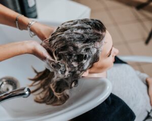 frau bekommt beim friseur ihre haare gewaschen