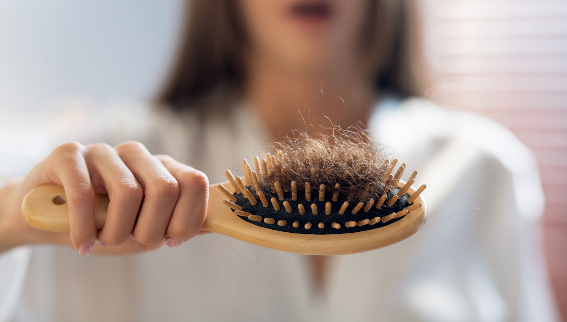 frau mit buerste haarausfall