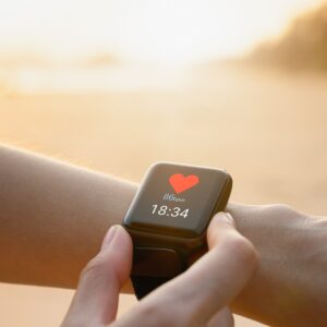 smartwatch an handgelenk vor strandkulisse