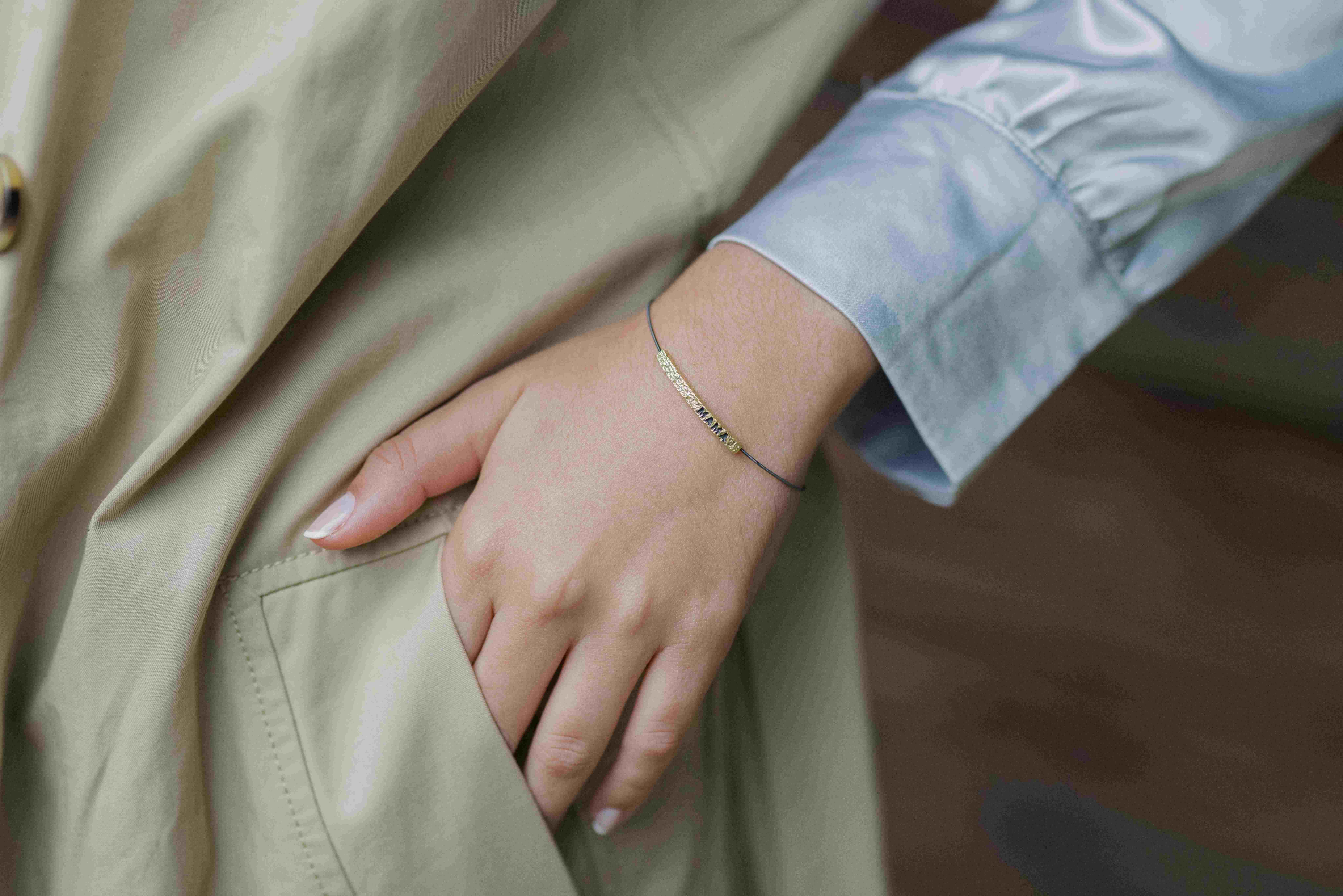 Hand einer Frau mit filigranem Goldarmband