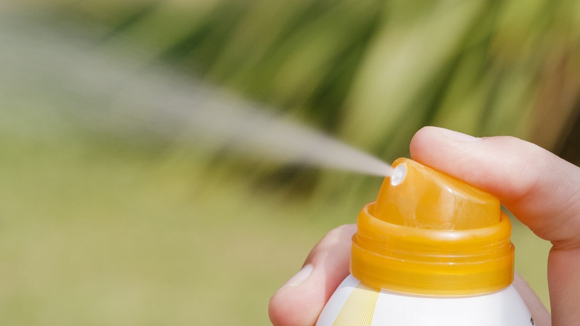 Sonnencreme aus einem Sprühkopf.