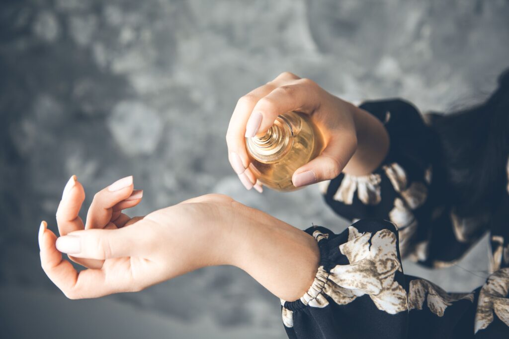 Eine Frau sprüht sich Parfum auf Ihr Handgelenk.