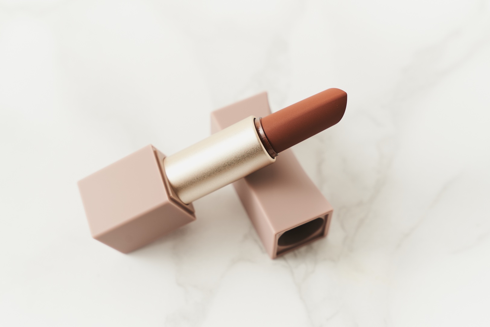Geöffneter Lippenstift liegt schräg auf seiner Schutzkappe.