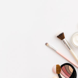 Eine Make-up-Sammlung ist auf einem Tisch ausgebreitet, daneben eine Make-up-Tasche.